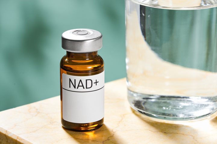 Amber pharmacy vial labelled NAD+ on warm marble, illustrating a performance & vitality compound discussed in this educational article